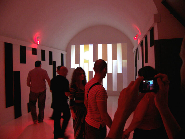 Installation view, Giovanni Scurria: Dynamic Common Computing, computer, custom software design, video projector, infrared lamps, infrared webcam, speakers, at Akneos, 2009.